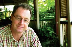 Photo of Professor Emeritus Darryl Jones in 2004 sitting outside with trees in the background.
