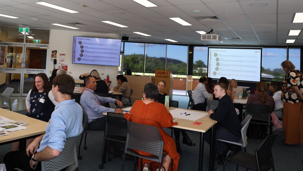 Groups of people sitting at tables in a seminar room. 