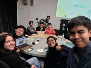 Dr Connie Gan at a round table with a group of smiling students.